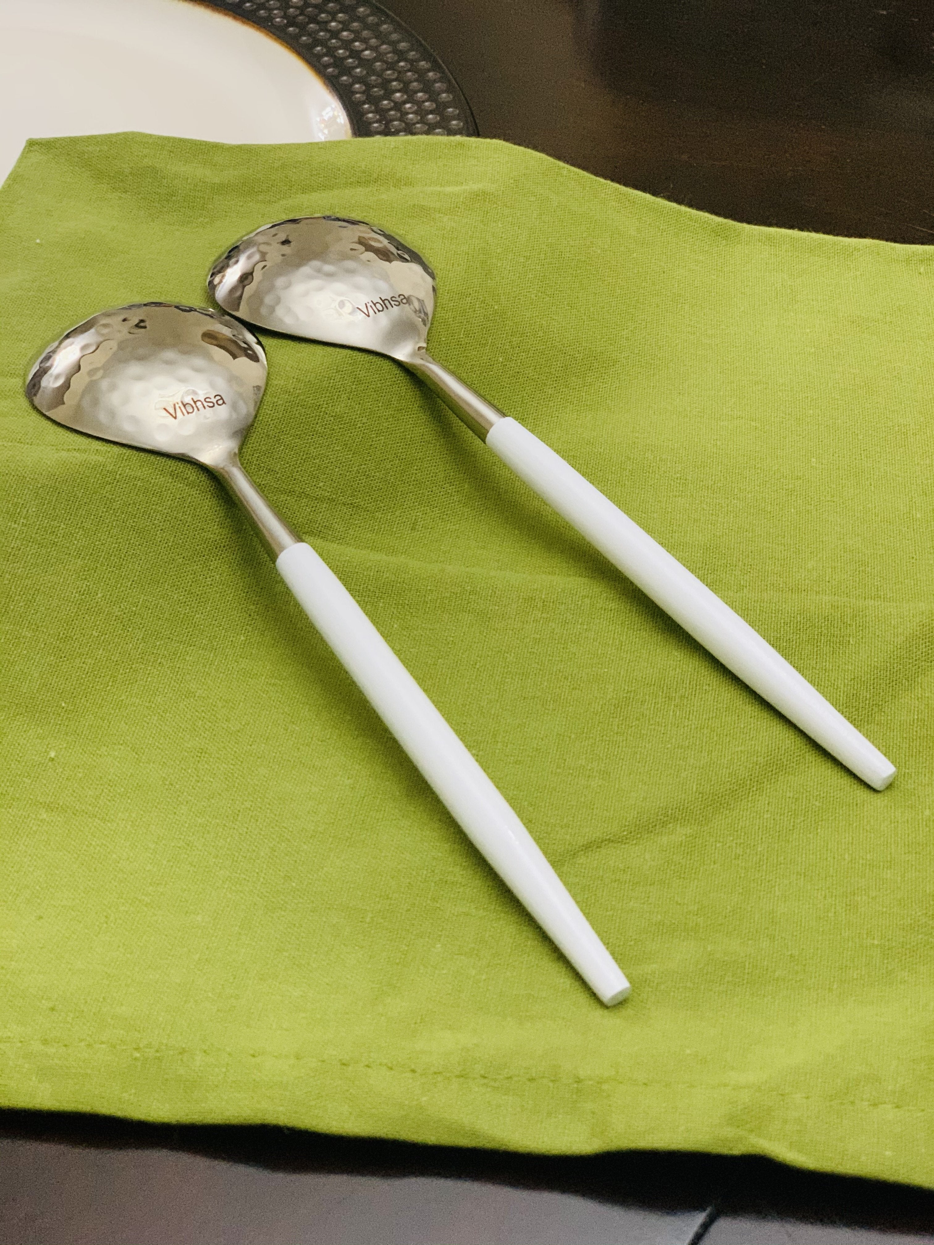 Vibhsa 6-PC Tablespoon Serving set with hammered mouth and white handles arranged on white plate.