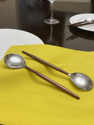 Set of six Vibhsa stainless steel tablespoons with hammered handles and polished brown finish.