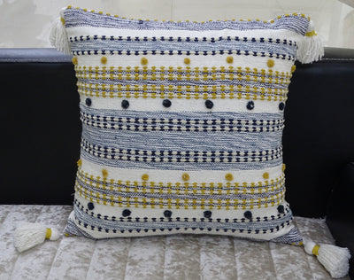 Designer Striped Pillow with mini pom-poms and tassels displayed on dark chair