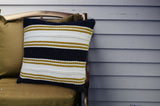 Multi Color 18x18 inch indoor outdoor pillow with braid detail resting on a sofa