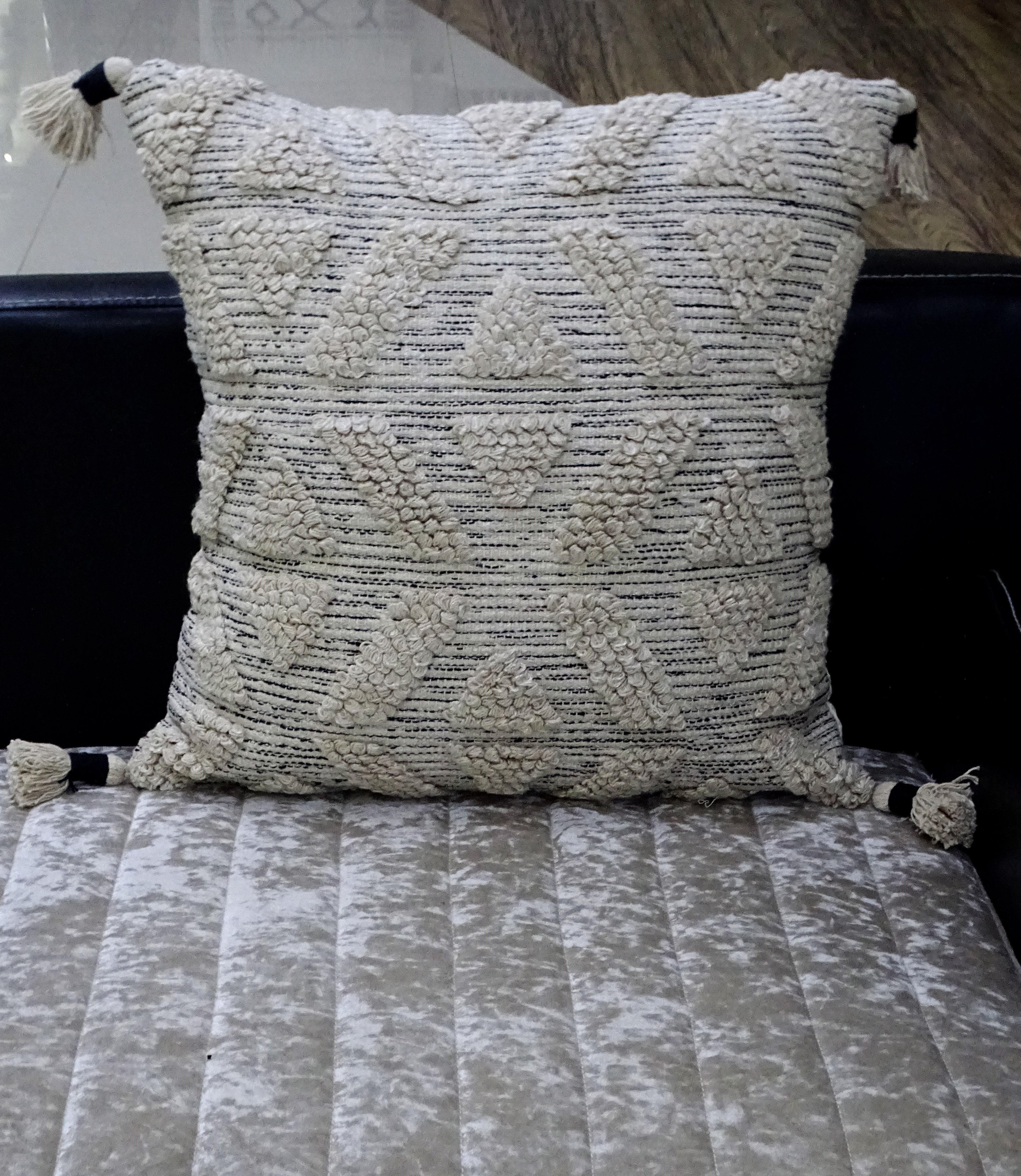 Large beige 22x22 throw pillow with embroidered pattern on a couch