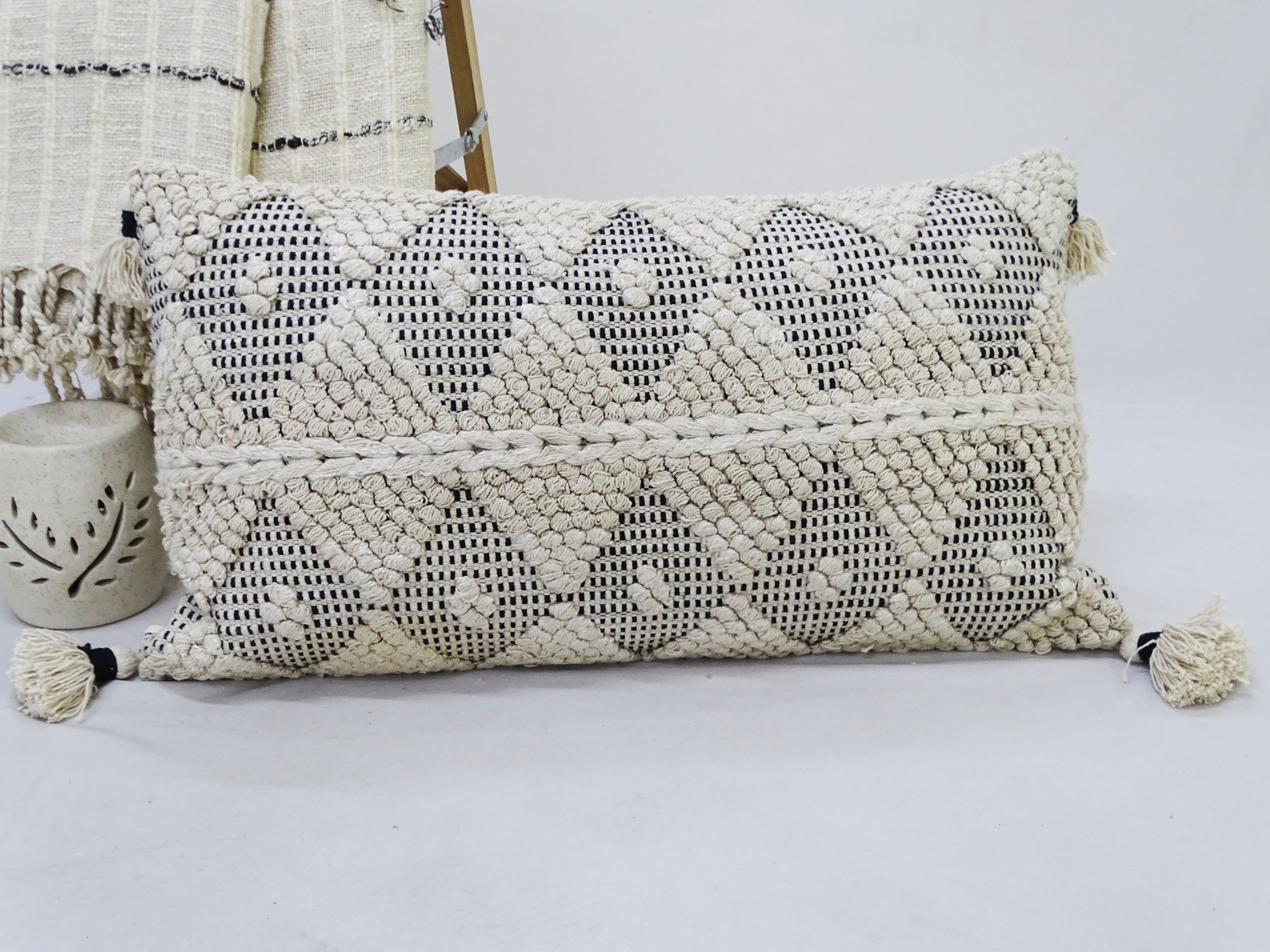 Vibhsa Accent Decorative Throw Pillow on sofa, showing textured woven surface and tassels