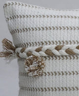 Close-up of a handwoven 14x24-inch throw pillow featuring beige and white horizontal stripes, a twisted rope detail, and a textured pom pom on the corner.
