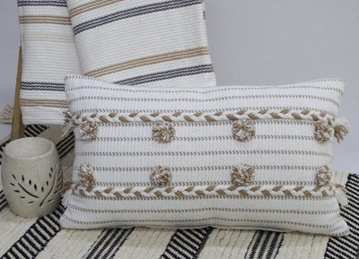 Handwoven 14" x 24" throw pillow in bright colors with braided textures and pom-poms on the edges