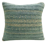 Square teal throw pillow with horizontal stitched patterns in beige including dots, zigzags, and lines, featuring a textured, woven fabric