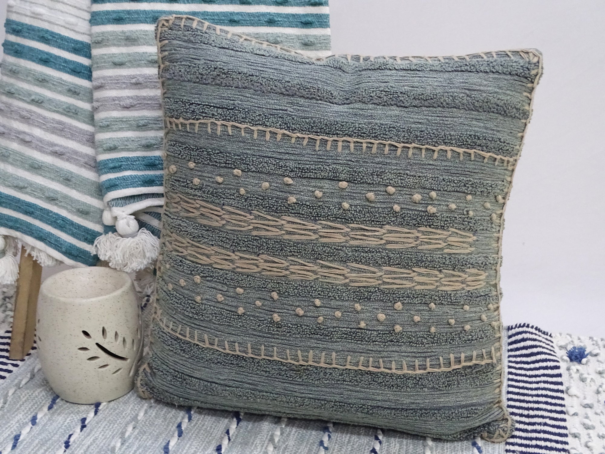 20x20 inch embroidery throw pillow with colorful front and solid back on couch