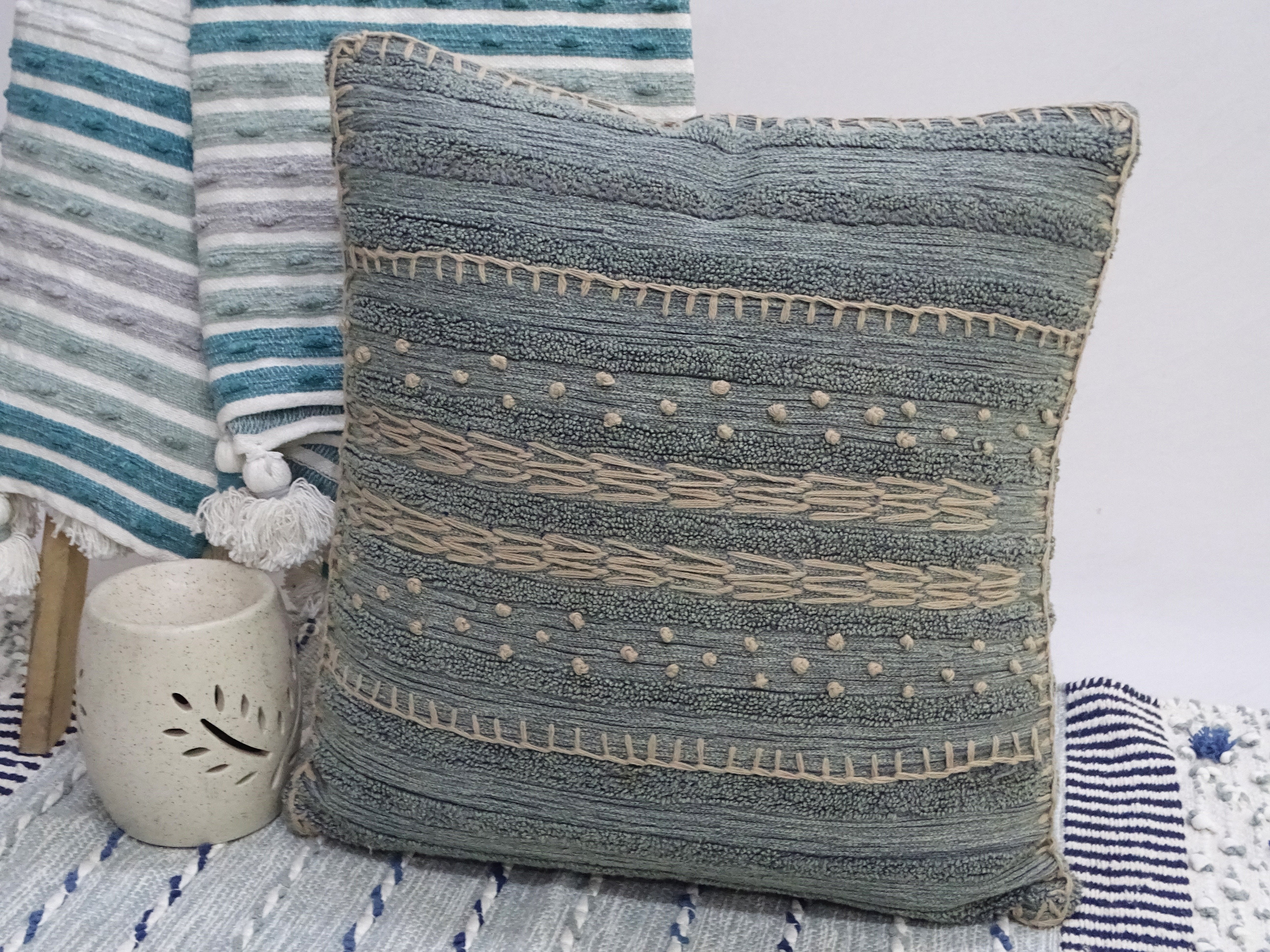 20x20 inch embroidery throw pillow with colorful front and solid back on couch