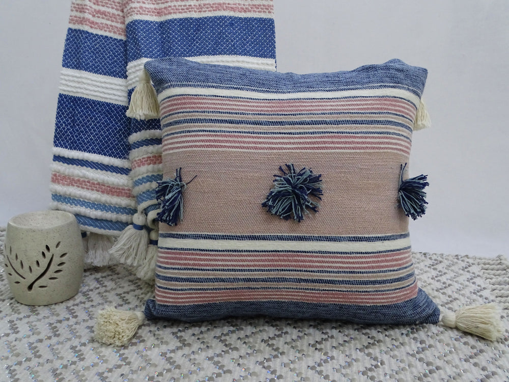 Throw pillow with colorful pom-poms and tassels on couch