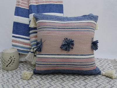 Throw pillow with colorful pom-poms and tassels on couch