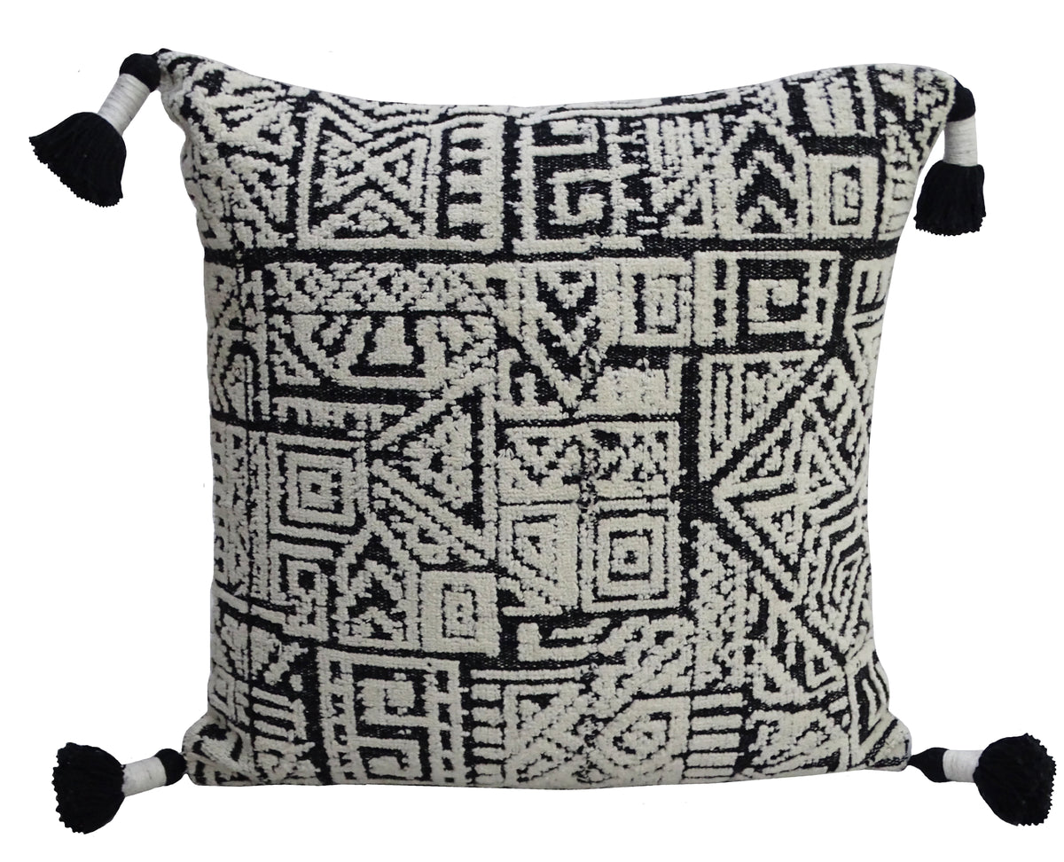 Square beige throw pillow with a black geometric Aztec-inspired pattern and black tassels on each corner.