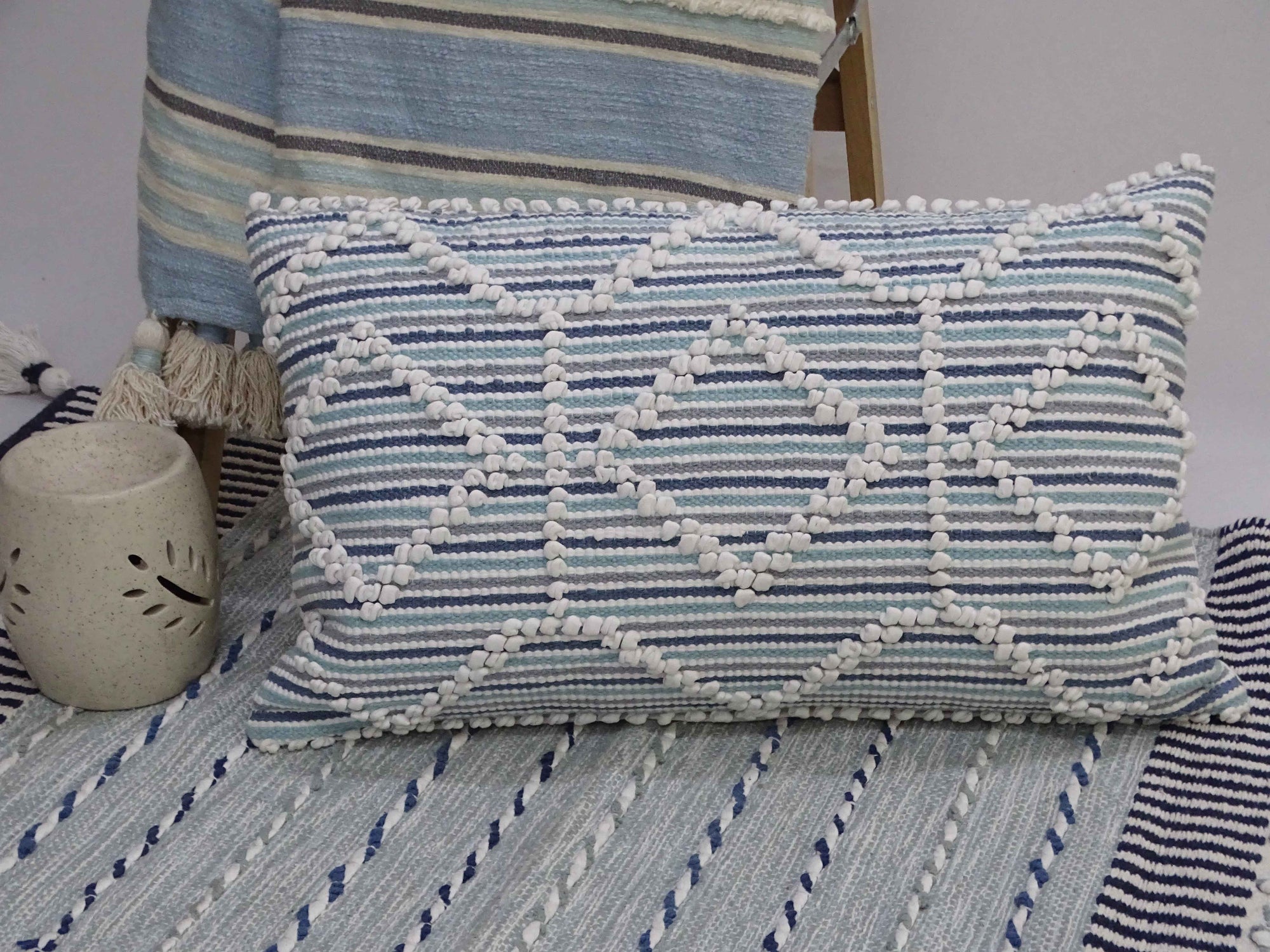 Modern handwoven colorful throw pillow 14x24 inches on a sofa