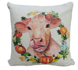 Square beige throw pillow featuring a watercolor-style cow face centered within a circular autumn wreath of pumpkins, leaves, and yellow flowers.