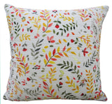Square decorative throw pillow with a white textured background and a pattern of small orange, yellow, red, and green leaf and berry branches.