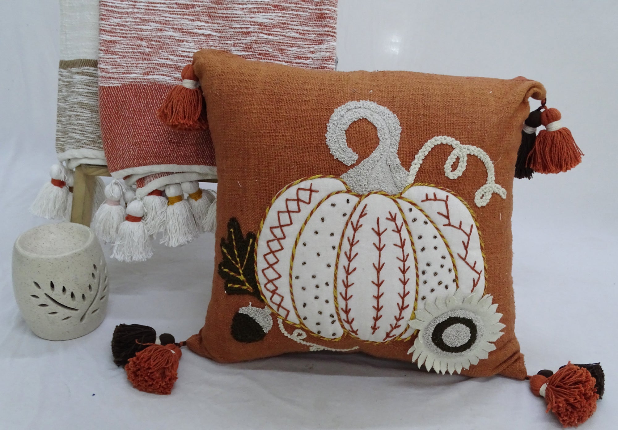 Fall Pumpkin Pillow with embroidered and printed design on a sofa