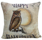 Square throw pillow with a vintage-style owl illustration perched on a branch in front of a large yellow moon, with 'Happy Halloween' text above and below in black.