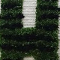 Close-up of green and white holiday embroidery on fabric, showing textured yarn in a raised pattern against a dark background.