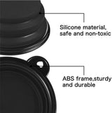 Close-up of a black collapsible dog bowl with labeled parts describing silicone material and sturdy ABS frame with a small heart-shaped hole on the rim.