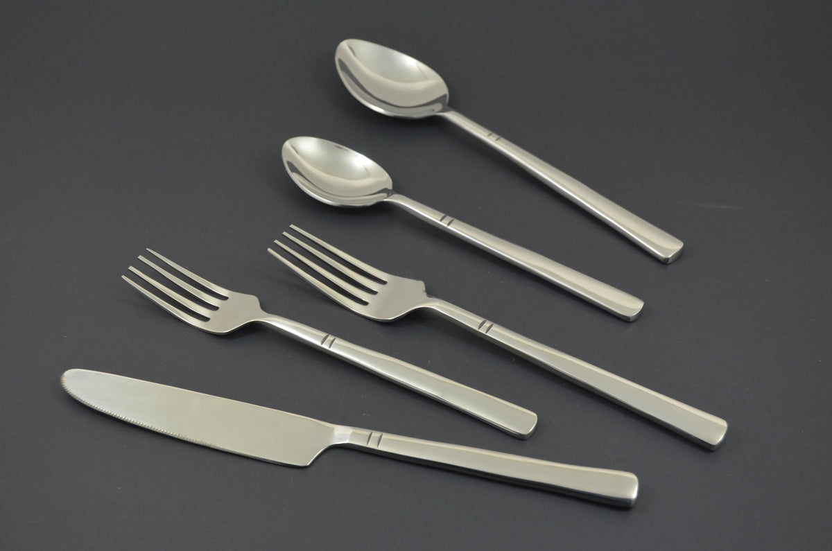 Five-piece stainless steel flatware set including a dinner knife, two forks, and two spoons with simple double-line detail on the handles, shown on a dark background.