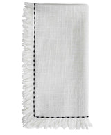Set of four white cotton napkins with black embroidery placed on a wooden table as dining decor