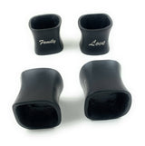 Set of four black resin napkin rings, two with rounded square shapes engraved with 'Family' and 'Love' in white script, displayed on white background.