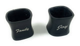 Two black ceramic napkin rings with curved sides, labeled with silver cursive text reading 'Family' and 'Joy' respectively, shown on a white background.