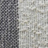Close-up of a handloom woven decorative throw pillow with textured fabric in contrasting shades of dark gray and off-white forming vertical stripes.