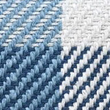 Close-up of a handloom woven textured plaid fabric in shades of blue, white, and gray with a visible diagonal weave pattern and soft fibers.