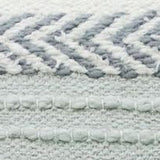 Close-up of a handloom woven decorative pillow showing textured zigzag and horizontal stripe patterns in soft cream and muted blue-gray colors.