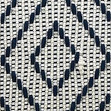 Close-up of a woven jacquard throw pillow fabric featuring a navy blue diamond pattern on a natural beige background with a textured weave.