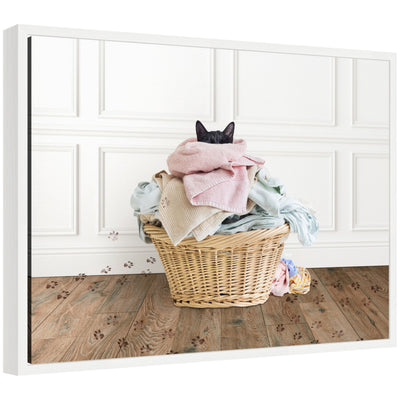 Framed canvas art showing a cat resting in a basket with folded laundry in a traditional laundry setting