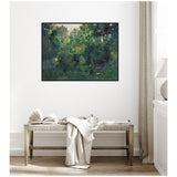 Framed canvas print of a lush green wooded landscape with dense trees and foliage, hanging above a wooden bench with an open book and draped fabric in a neutral-toned room.
