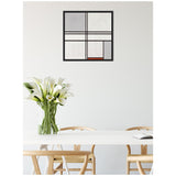Framed abstract Mondrian-style artwork with black lines and gray, white, and a small red block, hanging above a white table with light wooden chairs and a vase of white calla lilies.