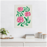 Framed canvas with three stylized pink flowers and curling green leaves on a light beige background, hanging above a white dresser with decor items.