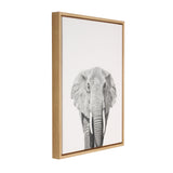 Front-facing black and white elephant portrait on a white canvas with a thin light wooden frame, photographed at a slight right angle.