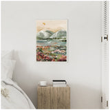 Framed canvas painting of a softly colored landscape with pale green mountains, a muted sky, and a foreground of pink and green floral brushstrokes, hanging above a wooden bedside table.