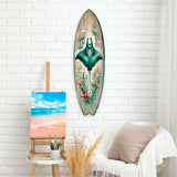 Wooden surfboard wall art featuring a large teal manta ray surrounded by pink and red sea creatures and plants, hanging on a white brick wall above a cozy white chair with a beige pillow.