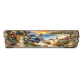 Wooden wall art featuring a sunset coastal scene with a vintage blue truck on a dirt path surrounded by lush greenery and a sandy beach with rocky shoreline.