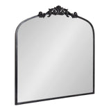 Rectangular mirror with an arched top and decorative black ornate scrollwork along the upper edge, framed in a slim black metal border.