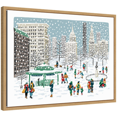 Framed canvas print showing a snowy scene in Union Square with people building snowmen and walking dogs among snow-covered trees and city buildings.
