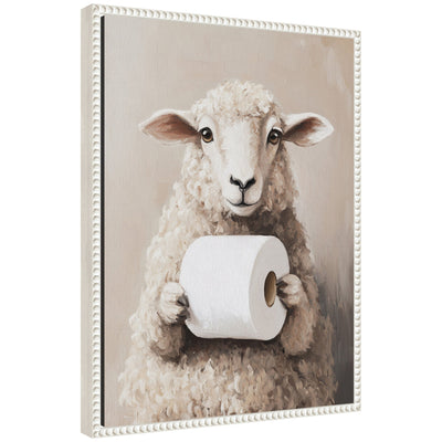 Framed canvas art showing a cute sheep holding a toilet paper roll with a vintage beaded frame, displayed in a bathroom setting.