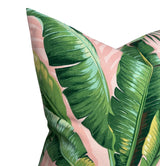 Close-up of a pillow cover featuring large green palm leaves with detailed veins against a soft pink background, emphasizing botanical contrast and texture.