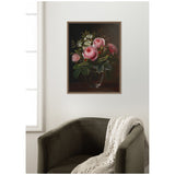 Framed painting of pink roses and white tree anemones in a glass vase on a dark background, hanging above an olive-green velvet armchair with a cream knit throw.