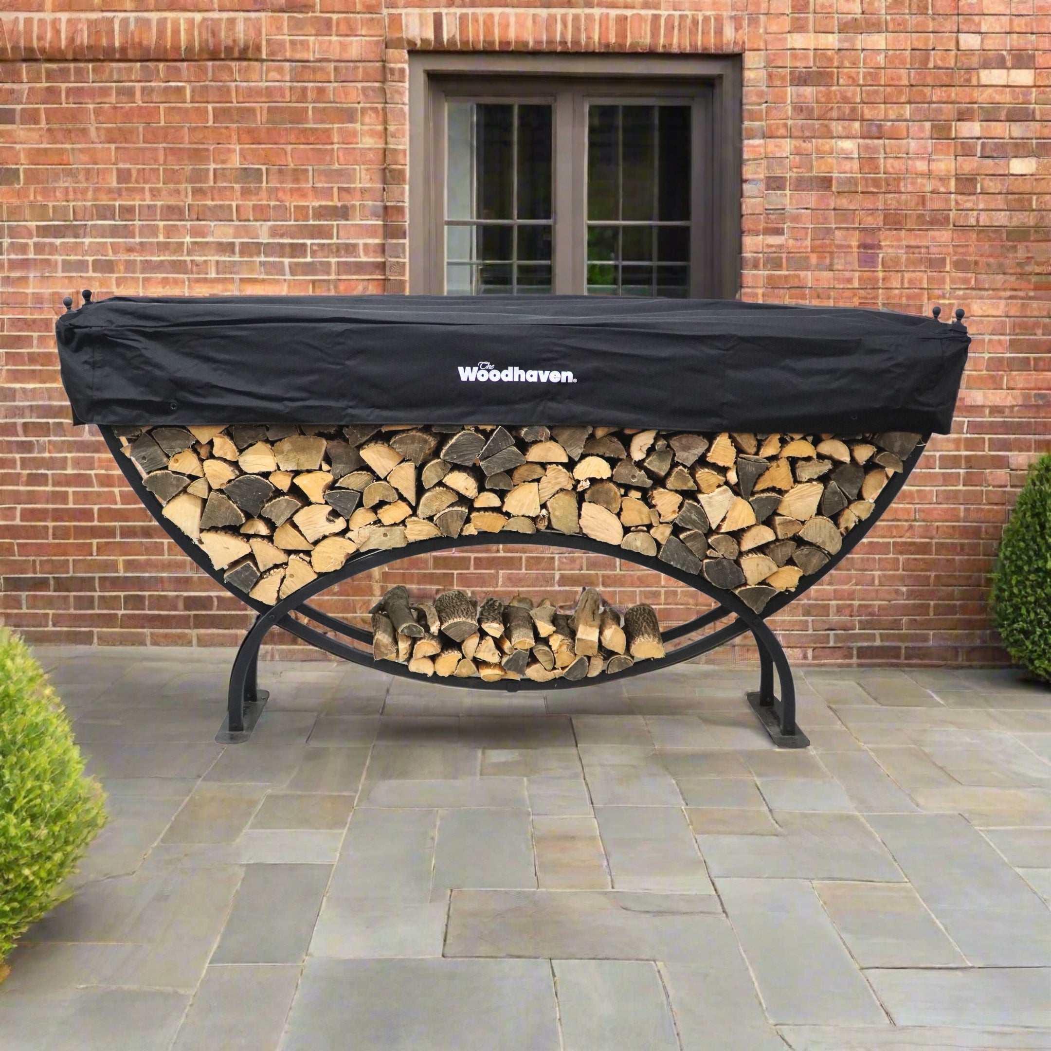 Woodhaven 8 ft Large Crescent Firewood Rack with seasoning cover holding firewood outside a house