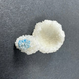 White stilbite crystal formation with a smaller spherical cluster of bright blue cavansite crystals attached, displayed on a dark gray background.