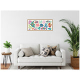 Framed canvas artwork featuring colorful tropical fish and coral shapes in bright blue, green, pink, purple, and orange hues, displayed above a white sofa in a minimalist living room.