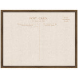 Framed linen fabric pinboard printed with vintage postcard layout text in brown, including divisions for message, address, and stamp area, in a dark wood frame.