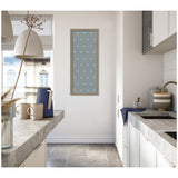 Minimalist kitchen with gray stone countertops, white cabinetry, a blue pitcher and mugs on the counter, and a framed blue botanical block print on the white wall