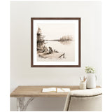 Sepia-toned framed artwork of two Adirondack chairs on a wooden dock by a calm lakeside with trees in the background, hanging above a wooden desk.
