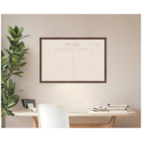 Rectangular framed fabric pinboard featuring a vintage postcard design with linen texture, hanging on a beige wall above a wooden desk with books and a plant.