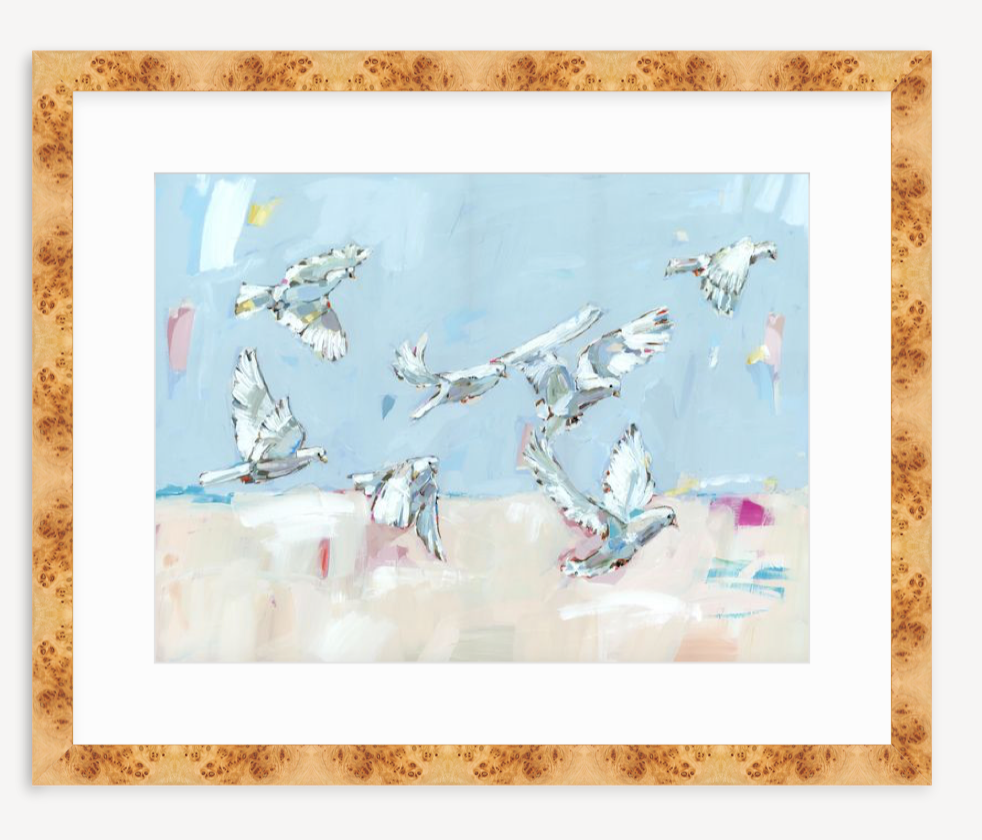 Fine art print depicting seven white doves in flight against a soft blue and beige abstract background, framed in a light wood frame.